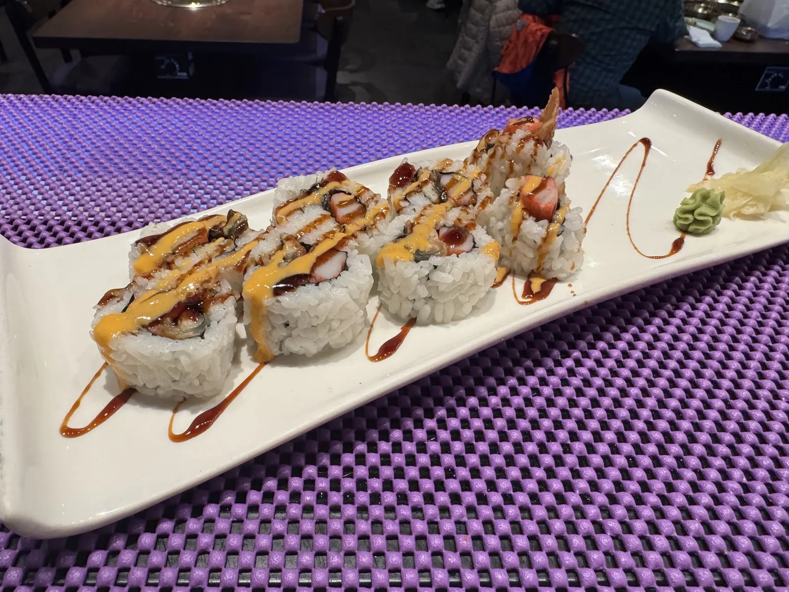 Eel and crab sushi roll on a white platter at Sendai