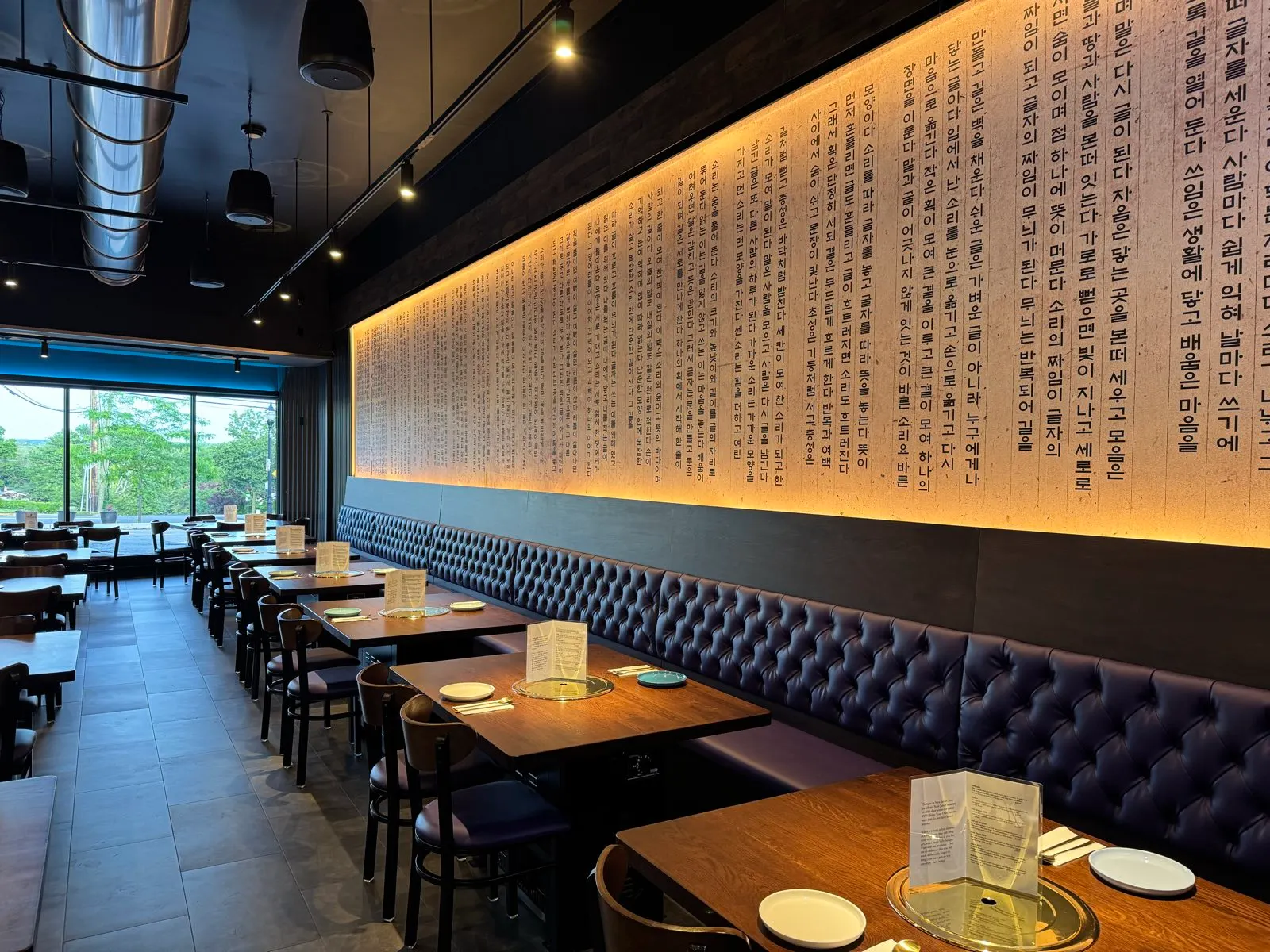 Booths along the backlit calligraphy wall in the Sendai dining room