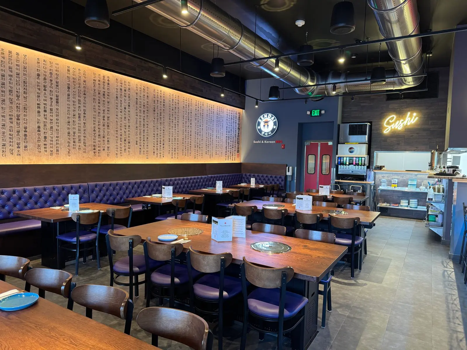 The Sendai dining room with grill tables, banquettes and the Sendai badge on the far wall