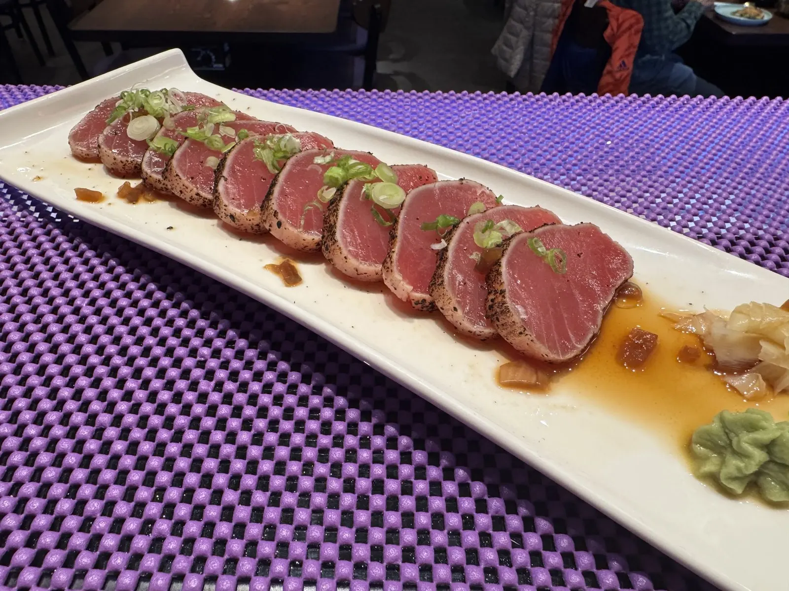 Seared tuna tataki sliced on a white platter at Sendai